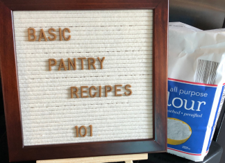A letter board sign in front of a bag of flour saying "Basic Pantry Recipes 101"